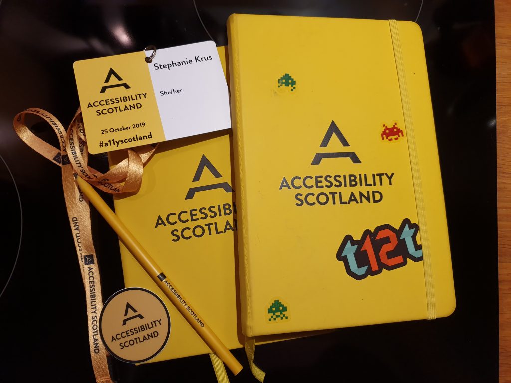 2 notepads (one from last year) a sticker, a pencil, all with Accessibility Scotland branding and my name badge