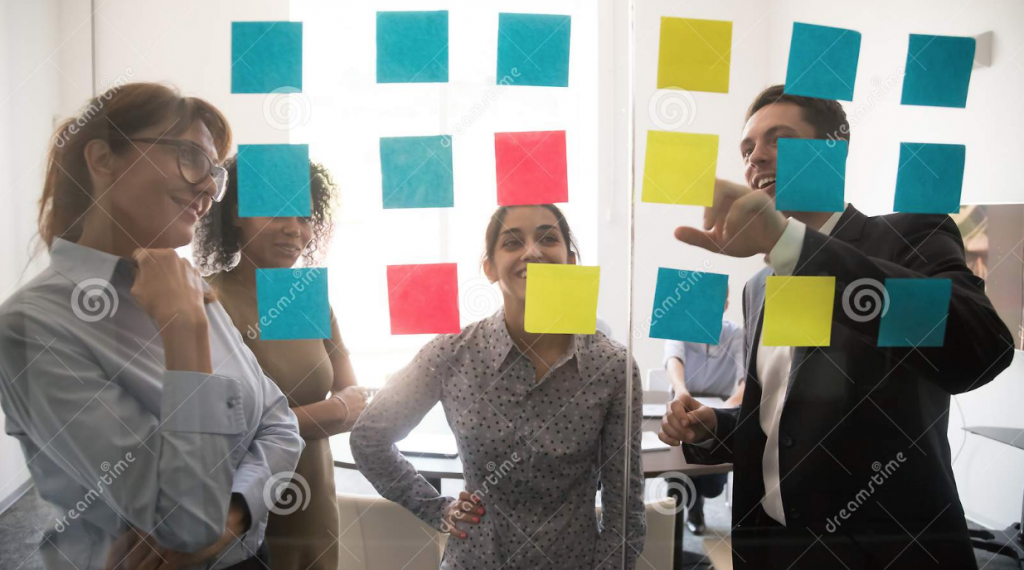 people standing in front of a glass wall with post it on it - stock type of photos