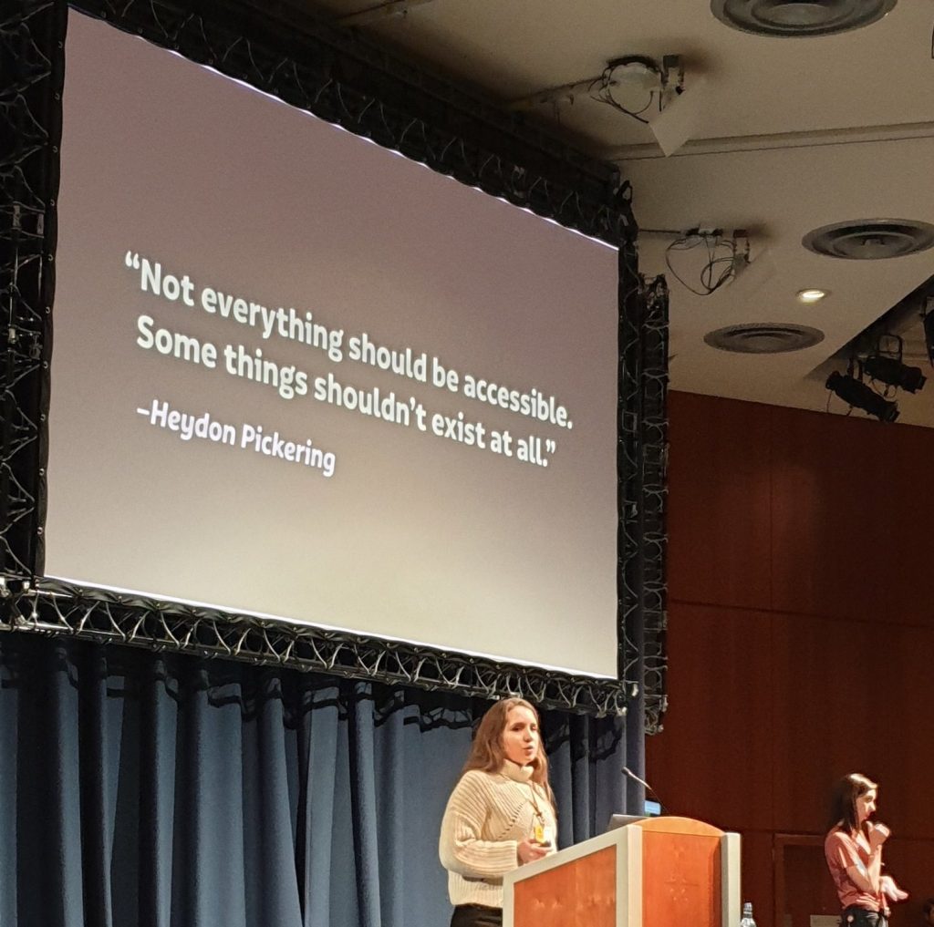Laura on stage with the quote behind on screen: not everything should be accessible. Some things should not exist at all.