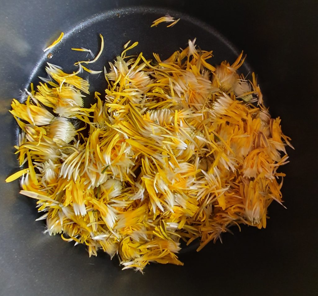 yellow petals in a dark pan - no water or juice yet