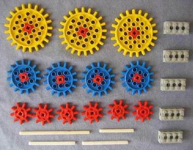 big yellow cogs with a red centre, medium blue cogs with a red centre and small red cogs, there are also grey bricks with holes in them and some plastic part to join them together