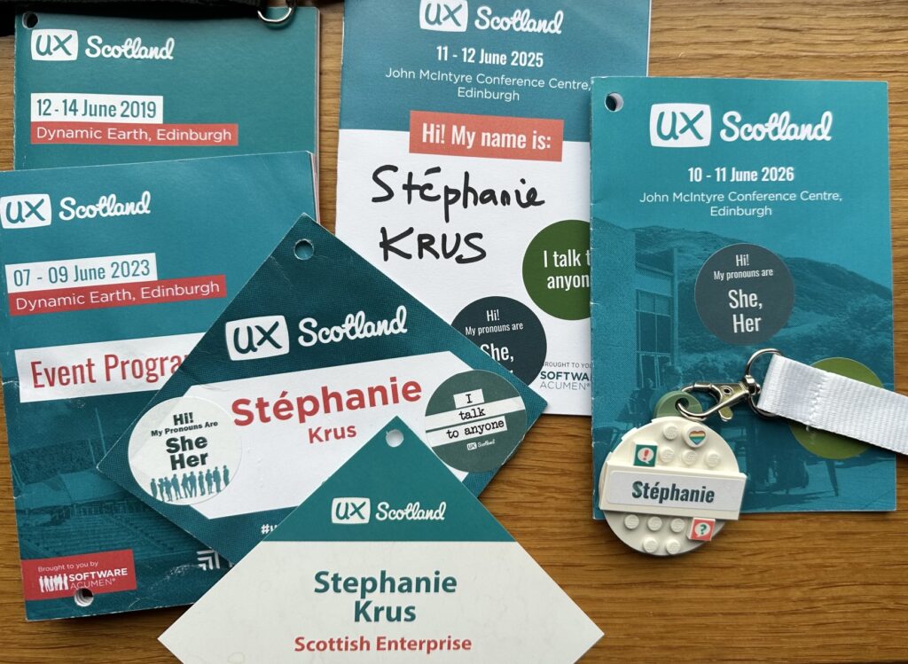 Different UX Scotland programmes from 2019, 2023, 2025 and this year, with various name badges from me where the font is bigger and you can see my surname as well. This year it's a round lego piece with my name on it in a smaller size with 3 little lego pieces to decorate it. Before it was paper version with a much bigger side and stickers on them